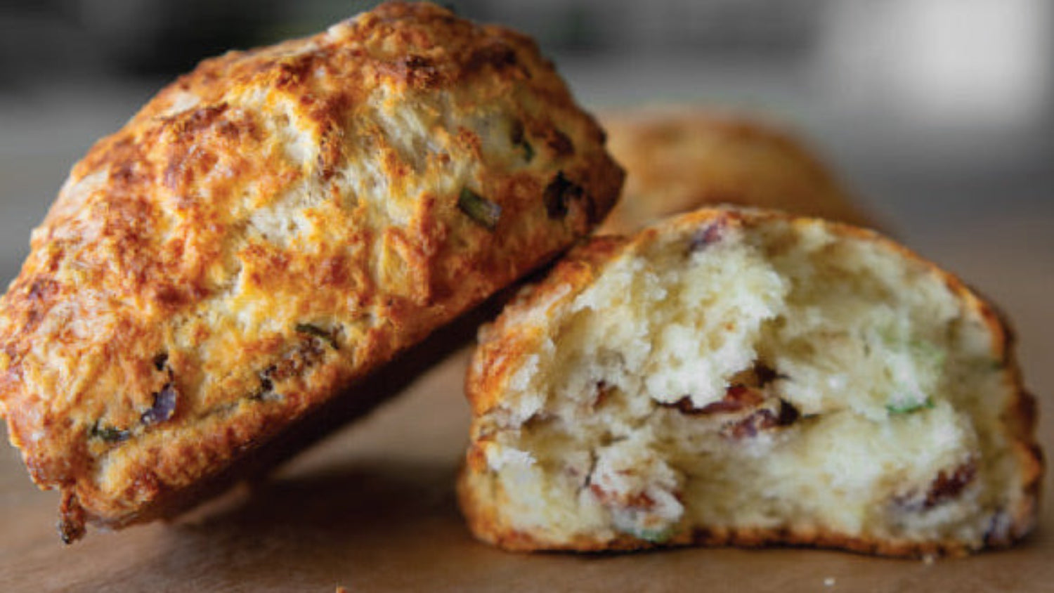 cross section of a savory scone on a wooden surface with a blurred background